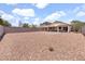 Expansive backyard with gravel, block wall, and covered patio at 1623 E Maplewood Ave, Buckeye, AZ 85326