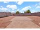 Large backyard with a gravel area, block wall, and tiled patio space at 1623 E Maplewood Ave, Buckeye, AZ 85326