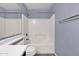 Clean bathroom with a full tub, shower, and blue accent walls at 1623 E Maplewood Ave, Buckeye, AZ 85326