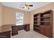 Bright bedroom featuring a ceiling fan, desk, and dark wood bookcase at 1623 E Maplewood Ave, Buckeye, AZ 85326