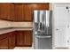 Kitchen boasts stainless steel refrigerator, complemented by ample wood cabinets and neutral-toned walls at 1623 E Maplewood Ave, Buckeye, AZ 85326