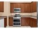 Well-equipped kitchen features stainless steel appliances, ample cabinet space, and tile flooring, designed for functionality at 1623 E Maplewood Ave, Buckeye, AZ 85326