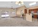 Open-concept living area features carpeted floors, recessed lighting, and seamless transition to kitchen with bar seating at 1623 E Maplewood Ave, Buckeye, AZ 85326