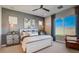 A modern bedroom features a ceiling fan, neutral decor, and large window for natural light at 16342 W Jackson St, Goodyear, AZ 85338