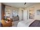 A modern bedroom with a seating area features neutral decor and access to the bathroom at 16342 W Jackson St, Goodyear, AZ 85338