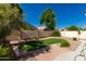 Fully landscaped backyard with manicured lawn, block wall, and desert landscaping at 1688 W Corriente Dr, San Tan Valley, AZ 85144
