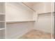 Spacious walk-in closet with shelving, rods, and neutral tile flooring at 1688 W Corriente Dr, San Tan Valley, AZ 85144