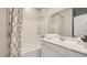 Well-lit bathroom with a shower-tub combo, white cabinetry, and ample counter space for toiletries and décor at 17387 W Whispering Wind Rd, Surprise, AZ 85387