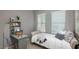 Comfortable bedroom with a built-in desk area, soft natural light, and cozy furnishings for a peaceful retreat at 17387 W Whispering Wind Rd, Surprise, AZ 85387