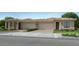 Charming, single story home boasting a tile roof, two car garage, neutral tones and mature landscaping at 17387 W Whispering Wind Rd, Surprise, AZ 85387