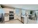 Bright kitchen featuring stainless appliances, modern white cabinets, tile flooring and adjacent dining area at 17387 W Whispering Wind Rd, Surprise, AZ 85387