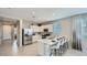 Modern kitchen featuring stainless appliances, white cabinets, quartz countertops, and bar stool seating at 17387 W Whispering Wind Rd, Surprise, AZ 85387