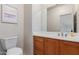 Bathroom featuring wood vanity, and a neutral colored wall with a framed print above the toilet at 1851 W Vermont Ave, Phoenix, AZ 85015