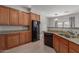 Kitchen with wood cabinetry, granite countertops, stainless steel sink, and black appliances at 1851 W Vermont Ave, Phoenix, AZ 85015