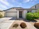 Charming single-story home featuring a two-car garage, covered entry, and meticulously landscaped front yard at 1953 W Stage Driver St, Apache Junction, AZ 85120