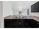 This well-lit kitchen boasts black cabinetry, an undermount stainless steel sink, and blends into the living area at 1953 W Stage Driver St, Apache Junction, AZ 85120