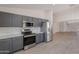 Modern kitchen features stainless steel appliances, gray cabinets, light countertops, and open access to living spaces at 23852 W La Salle St, Buckeye, AZ 85326