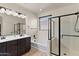 Well-lit bathroom with a double vanity, shower, soaking tub, and modern black hardware at 3326 N 31St St, Mesa, AZ 85213