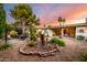 Backyard garden with brick-lined beds, mature trees, covered patio, and comfortable seating area at 4046 E Crocus Dr, Phoenix, AZ 85032