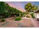 Backyard featuring a decorative garden trellis, lush landscaping, and charming brick accents at 4046 E Crocus Dr, Phoenix, AZ 85032