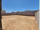 Large dirt backyard enclosed by block fencing offers an adaptable space for landscaping and outdoor enjoyment at 4195 W Lisa Ln, San Tan Valley, AZ 85144