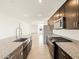 Open kitchen featuring stainless steel appliances, dark wood cabinetry, and granite countertops at 4195 W Lisa Ln, San Tan Valley, AZ 85144