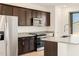 Modern kitchen features stainless steel appliances, granite countertops, and dark wood cabinetry at 4195 W Lisa Ln, San Tan Valley, AZ 85144
