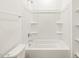 Bright, clean bathroom shower-tub combo, toilet, and white wall shelving at 4195 W Lisa Ln, San Tan Valley, AZ 85144