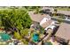 Aerial view of a backyard with a sparkling pool, covered patio, lush greenery, and a play area at 4530 E Decatur St, Mesa, AZ 85205