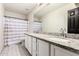 Bathroom featuring dual vanity sinks with granite countertop, white cabinets, and hexagonal tile floor at 4530 E Decatur St, Mesa, AZ 85205