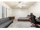 Neutral bedroom features carpet, window with shutters, ceiling fan, futon, and gaming chair at 4530 E Decatur St, Mesa, AZ 85205