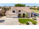 Two-story home with neutral colors, a well manicured yard, a three-car garage, and mature palm trees at 4530 E Decatur St, Mesa, AZ 85205