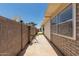 Side yard with a concrete walkway, tan brick wall and the house exterior at 505 S Ridge --, Mesa, AZ 85204