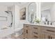Modern bathroom featuring a marble-tiled shower, double vanity with black faucets, and elegant lighting at 5401 E Van Buren St # 1088, Phoenix, AZ 85008