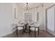 Dining room with a modern chandelier, a round wood table, and chic white chairs at 5401 E Van Buren St # 1088, Phoenix, AZ 85008