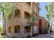 Exterior view of three-story condo building showing balconies, terraces, windows, and desert landscaping at 5401 E Van Buren St # 1088, Phoenix, AZ 85008