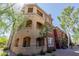 Three-story exterior view of condo showing balconies and arched ground floor terraces with desert landscaping at 5401 E Van Buren St # 1088, Phoenix, AZ 85008