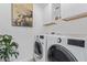Modern laundry room with white washer and dryer, overhead cabinets, and a houseplant at 5401 E Van Buren St # 1088, Phoenix, AZ 85008