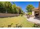 Spacious backyard with green grass, a tiled patio, a pool, and ample space for outdoor activities and entertaining at 5534 W Riviera Dr, Glendale, AZ 85304