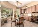 Bright breakfast nook features a glass table, backyard pool view, and built in cabinets at 5534 W Riviera Dr, Glendale, AZ 85304