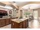 Open-concept kitchen showcasing granite countertops, custom cabinets, a spacious island and tile floors at 5534 W Riviera Dr, Glendale, AZ 85304