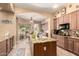 Spacious kitchen with an island, granite counters, custom cabinets, and views into the breakfast nook and backyard at 5534 W Riviera Dr, Glendale, AZ 85304