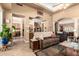 Open-concept living room featuring neutral colors, tile flooring, and views of the kitchen and dining room at 5534 W Riviera Dr, Glendale, AZ 85304