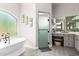 Bright bathroom features a soaking tub, frosted glass shower, and a vanity area at 5534 W Riviera Dr, Glendale, AZ 85304