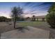 Private backyard with an in-ground pool, grassy area, rock landscaping, and a covered patio at 5919 W Blackhawk Dr, Glendale, AZ 85308