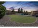 Well-maintained backyard with lush lawn, rock landscaping, and a refreshing private pool at 5919 W Blackhawk Dr, Glendale, AZ 85308