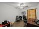 Functional office space with a ceiling fan, desk, multiple chairs, and a neutral colored flooring at 6008 W Augusta Ave, Glendale, AZ 85301