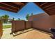 Secluded patio with brick pavers, enclosed by a fence, offering a glimpse of a green common area and swimming pool at 6008 W Augusta Ave, Glendale, AZ 85301