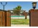 View of a community pool featuring a metal fence, pergola, and grassy area at 6008 W Augusta Ave, Glendale, AZ 85301