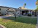 Well-manicured lawn complements this desert home with a two-car garage and trimmed landscaping at 7027 W Midway Ave, Glendale, AZ 85303
